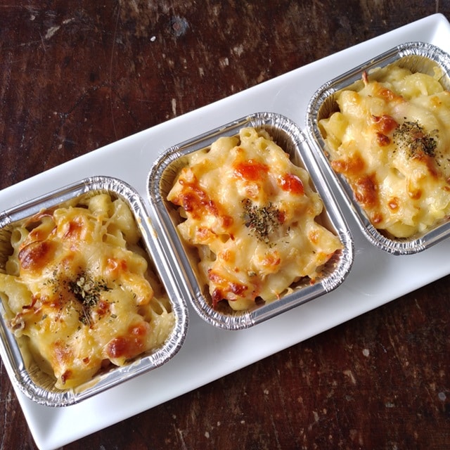Cheese pasta grilled in aluminum foil and served on a wooden table