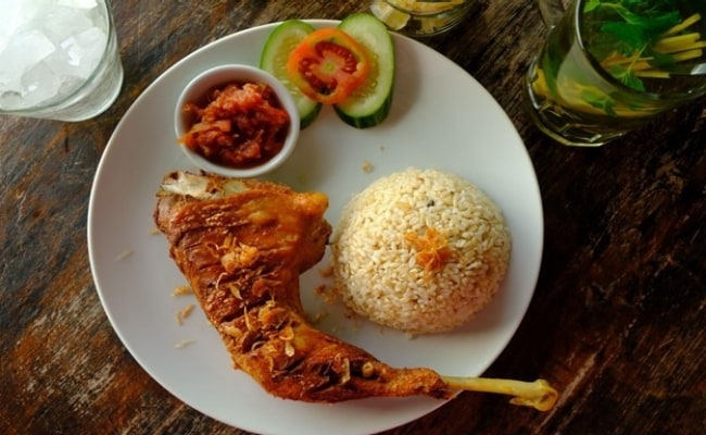 Seperti yang terlihat pada foto, ada ayam kampung goreng yang disajikan bersama nasi uduk.