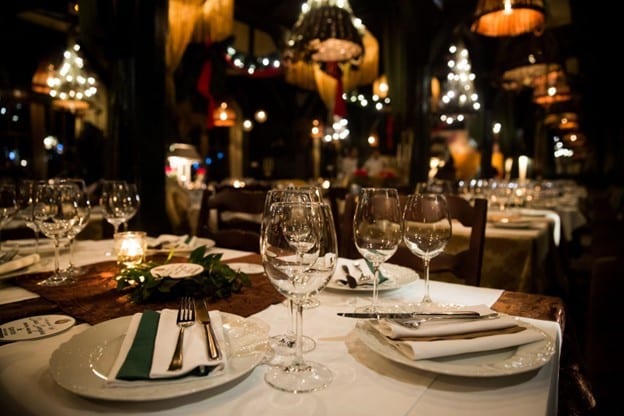 Meja makan restoran yang ditata dengan berbagai peralatan makan elegan dan terkesan mahal Meja makan restoran yang ditata dengan berbagai peralatan makan elegan dan terkesan mahal