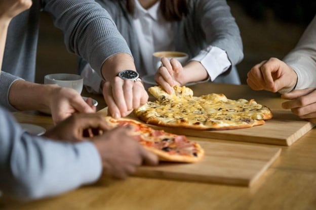 Dua jenis pizza disajikan di atas meja restoran Dua jenis pizza disajikan di atas meja restoran