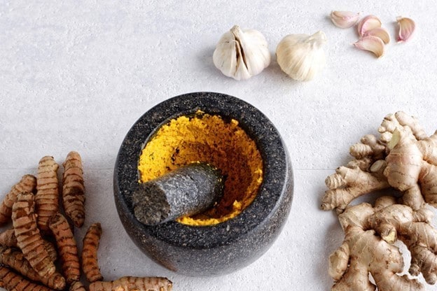 Bumbu dasar kuning dalam ulekan. Bumbu dasar kuning dalam ulekan.