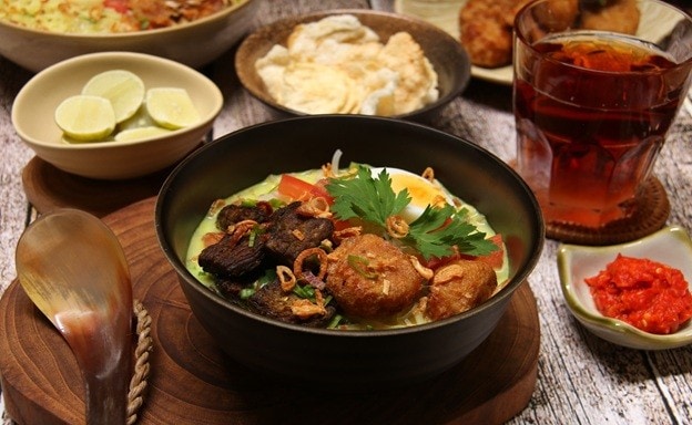 Soto Medan dikelilingi teh, emping, dan sambal.
