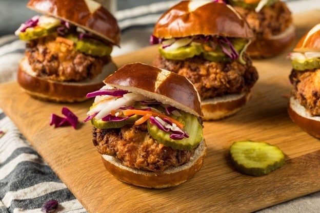 Beberapa chicken sandwich ditata di atas wooden board