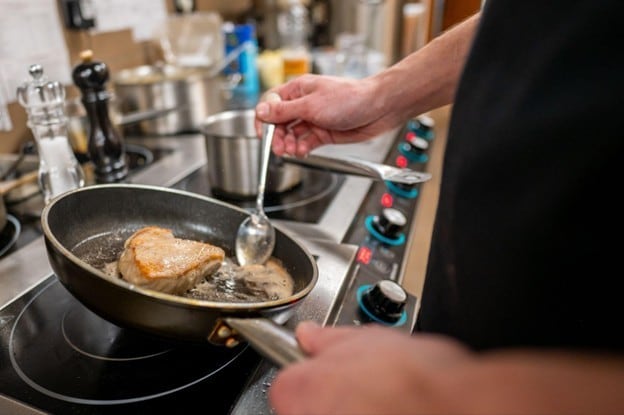 Tangan chef yang sedang melakukan butter basting. Tangan chef yang sedang melakukan butter basting.