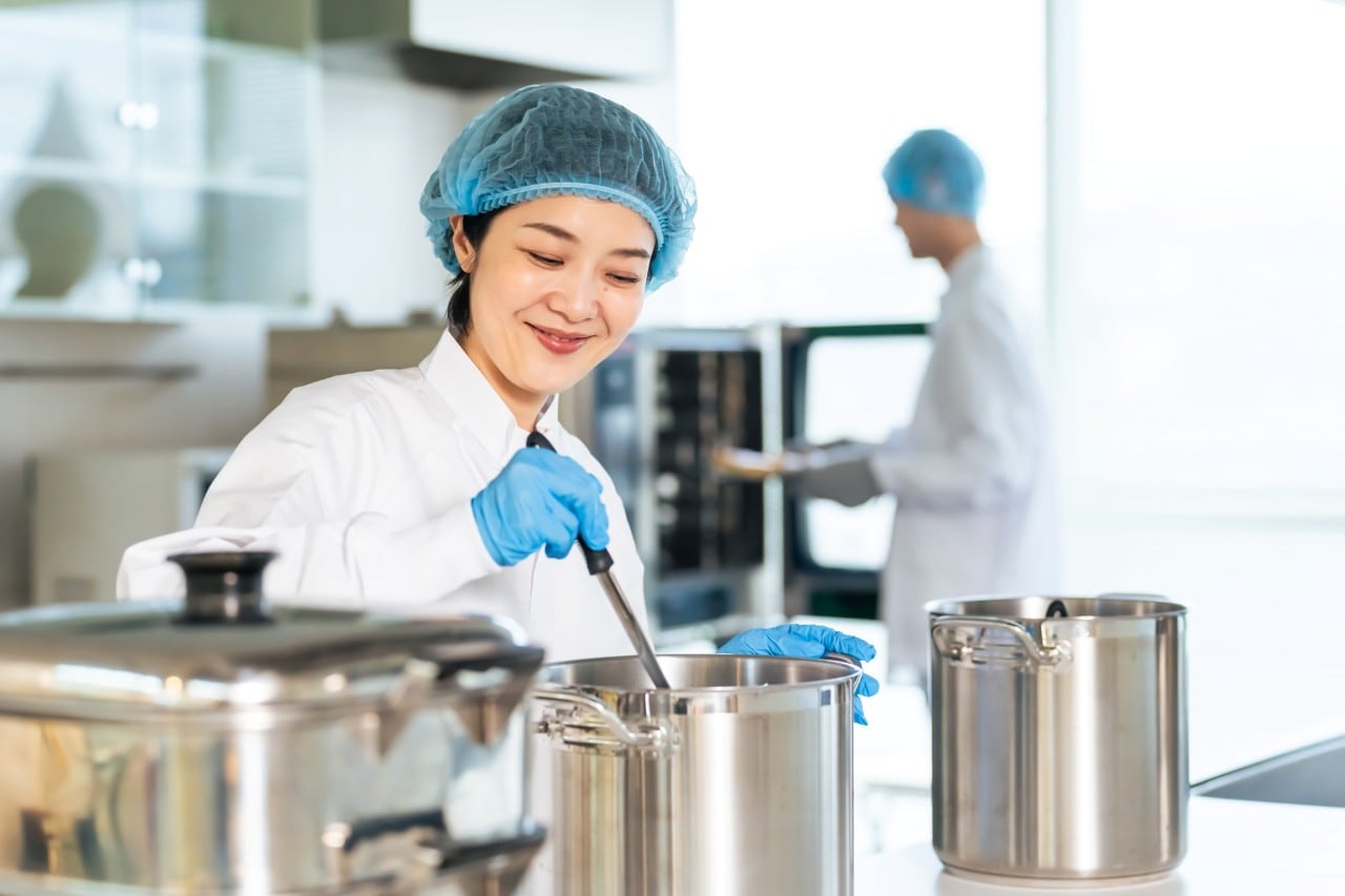 Chef sedang memasak menggunakan stock pot. 