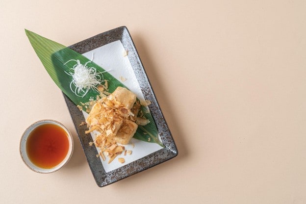 Seperti yang terlihat pada gambar, potongan tahu goreng ditata di atas piring persegi