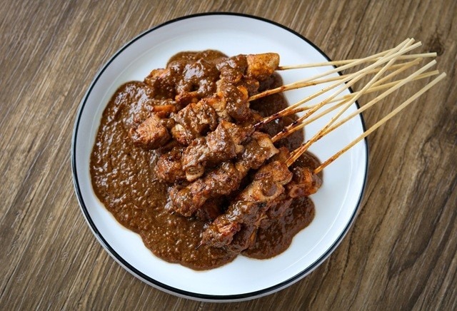 Sate ayam dilumuri dengan bumbu kacang. 