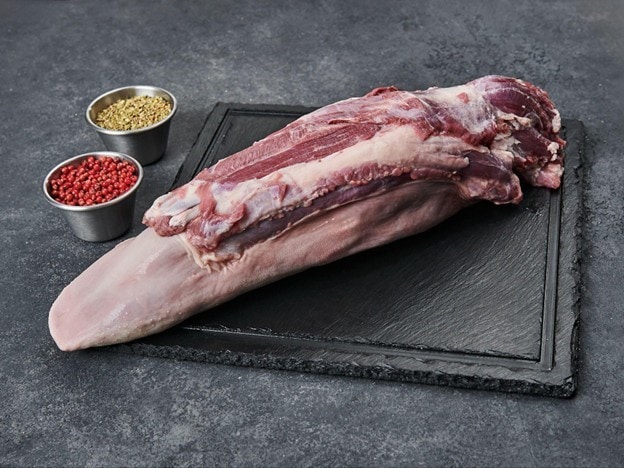 Lidah sapi di atas talenan hitam dengan pink peppercorns dan dry herbs.