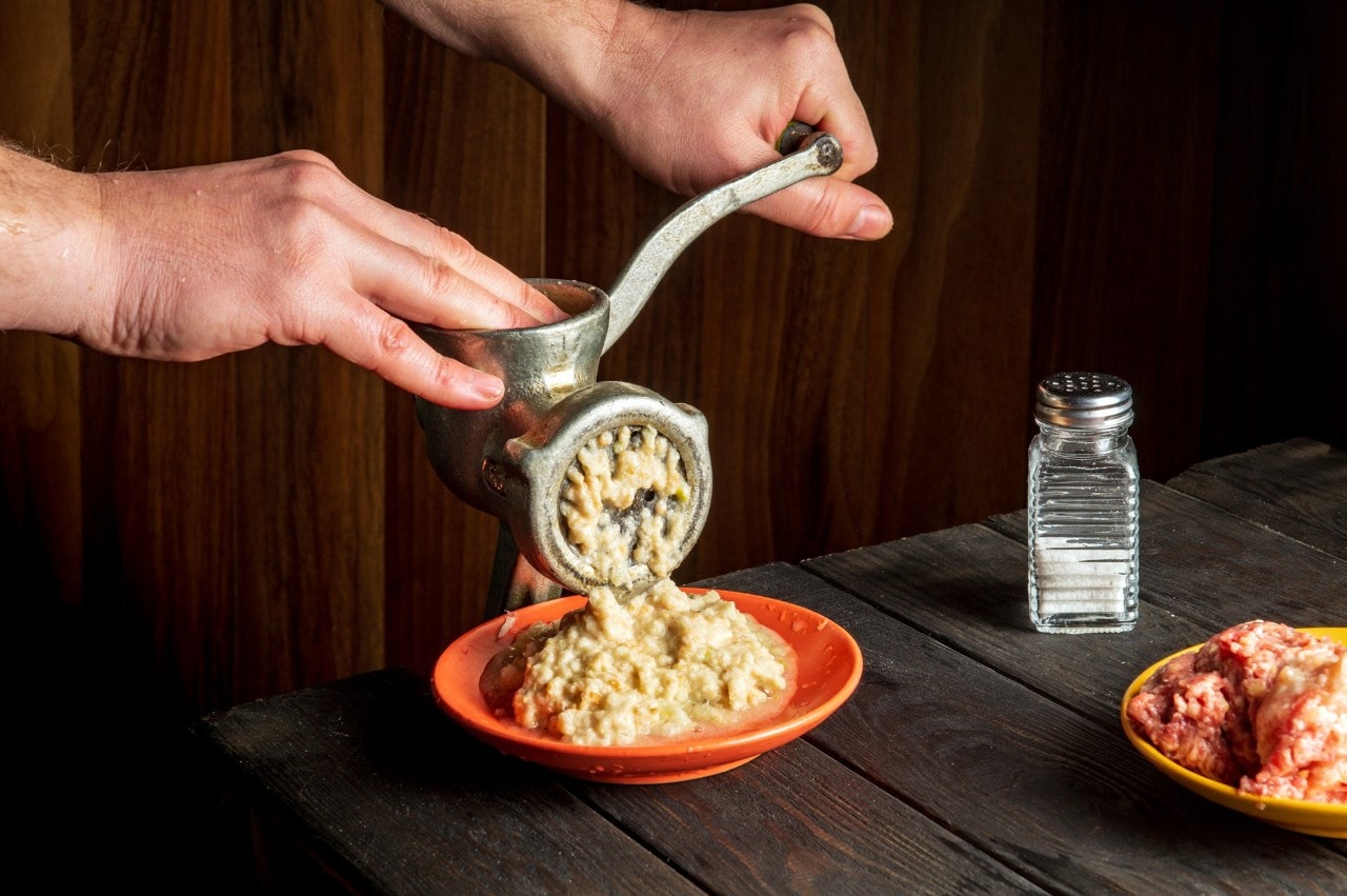 Tangan chef sedang menghaluskan bumbu.  