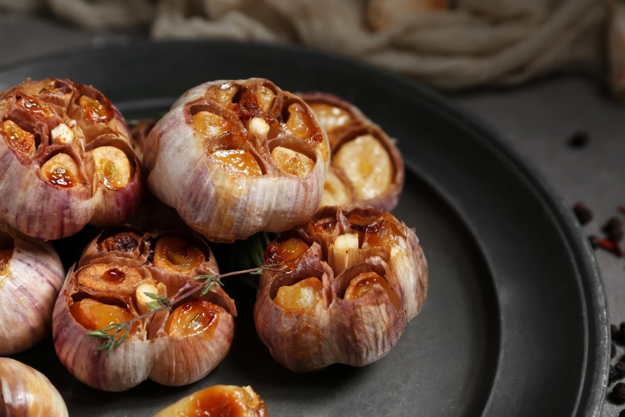 Bawang putih panggang di atas piring. 