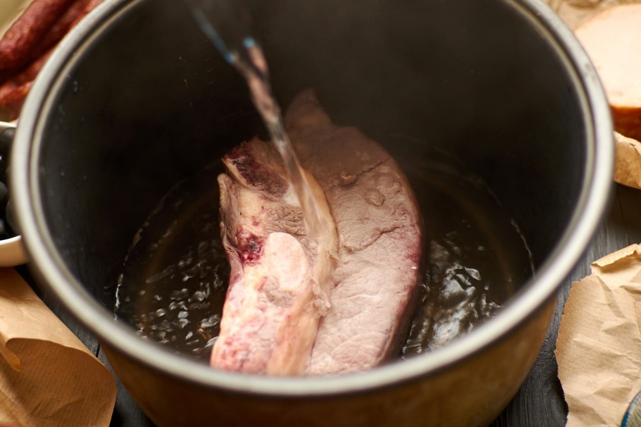 Seperti yang terlihat pada gambar, proses menuang air sebelum merebus daging dalam panci