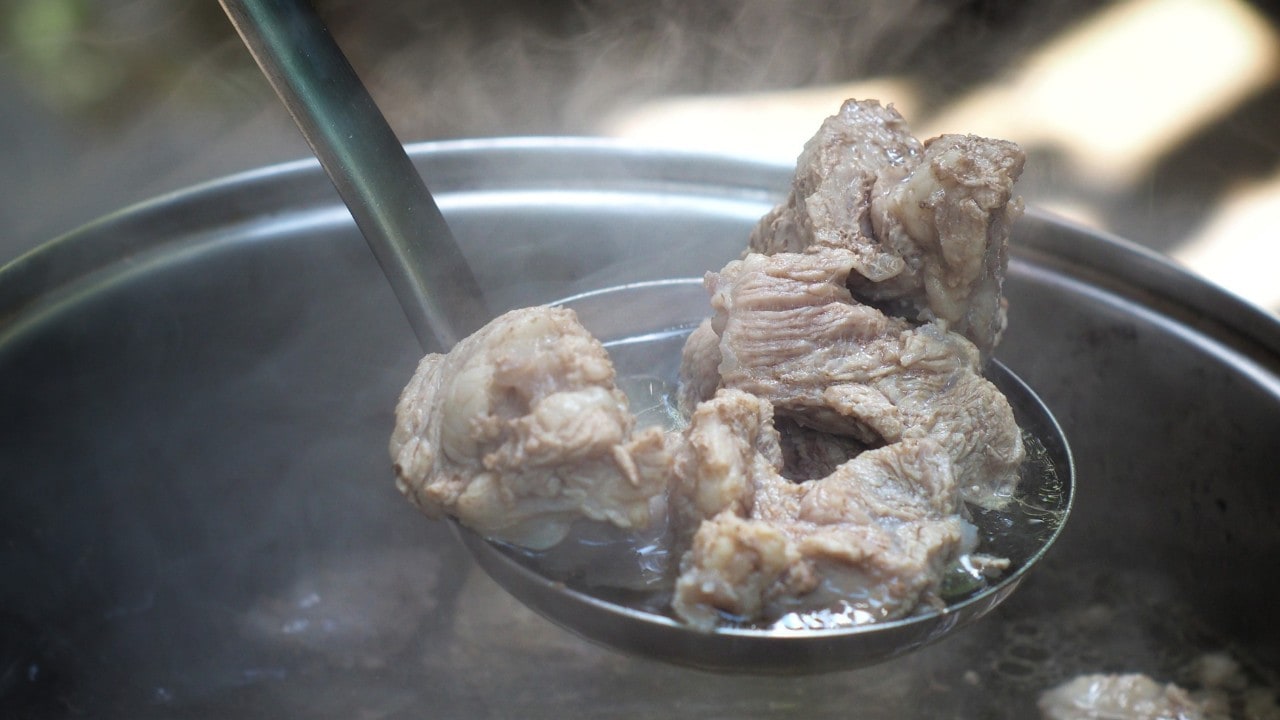 Seperti yang terlihat pada gambar, potongan daging sapi sedang direbus dalam panci