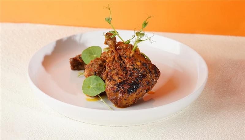Seporsi ayam napinadar disajikan di atas piring keramik putih Seporsi ayam napinadar disajikan di atas piring keramik putih
