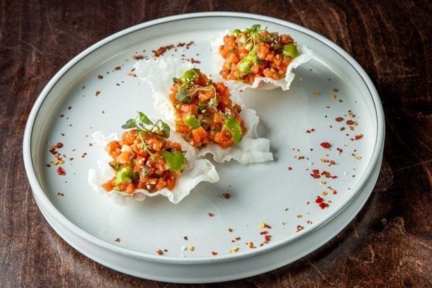 Seperti yang terlihat pada gambar, hidangan gourmet disajikan dengan plating estetik di atas piring putih