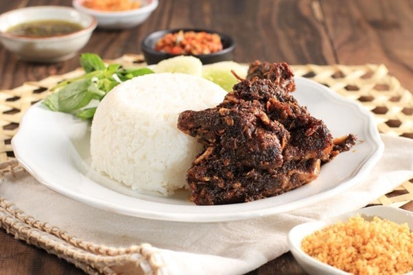Seperti yang terlihat pada gambar, seporsi nasi bebek dengan sambal hitam disajikan dengan pelengkap