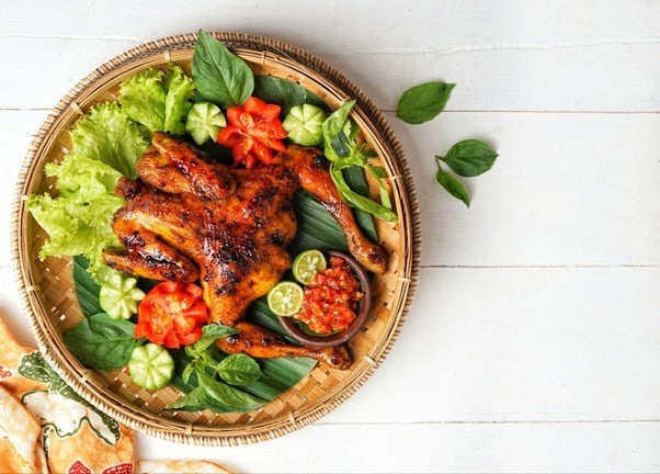 Seperti yang terlihat pada gambar, ayam bakakak ditata dalam nampan dengan pelengkapnya