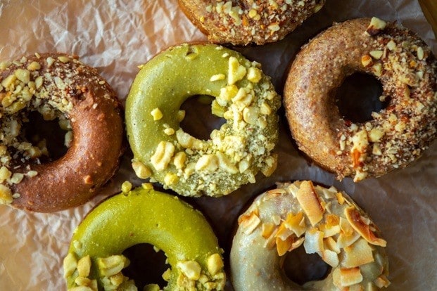 Donat dengan topping modern seperti pistachio, coconut flakes, dan kacang-kacangan.