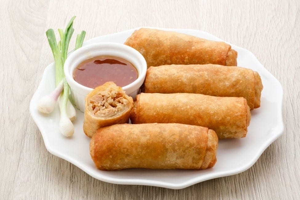 Empat potong lumpia disajikan di atas piring putih Empat potong lumpia disajikan di atas piring putih