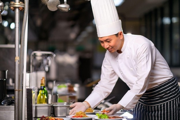 Seperti yang terlihat pada gambar, chef sedang menata hidangan