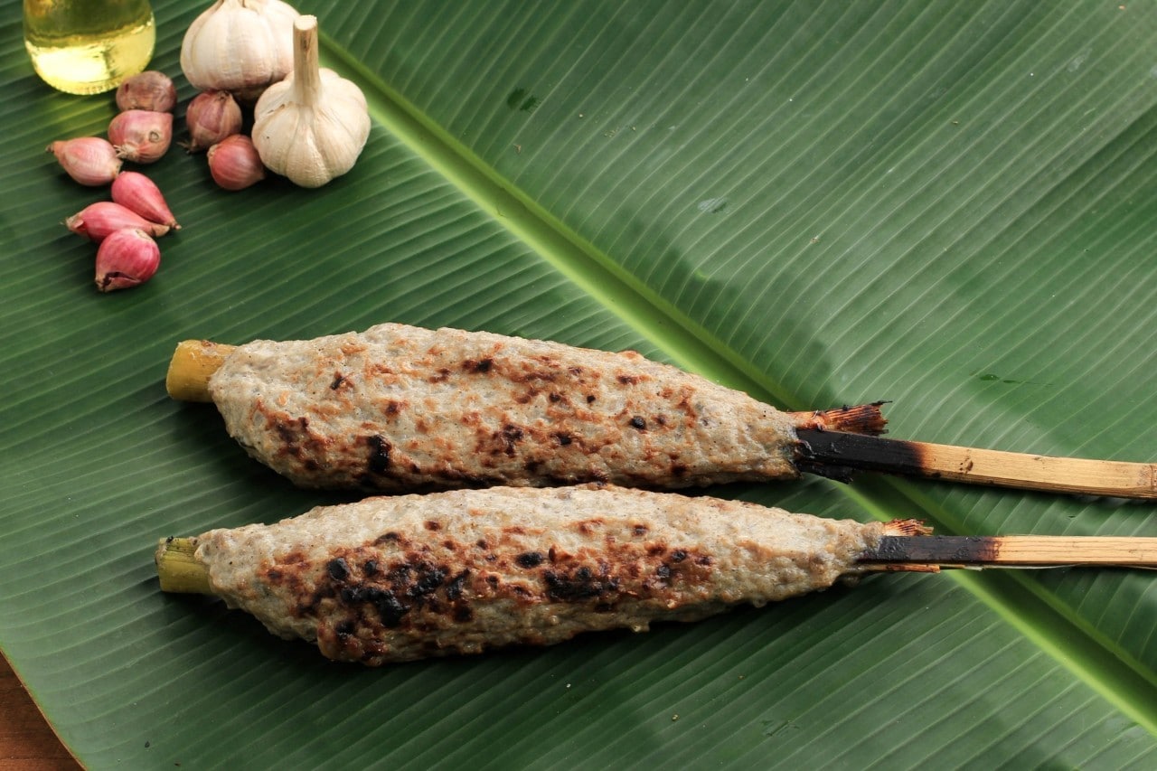 Dua sate bandeng di atas daun pisang. 