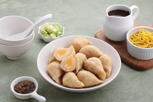 Sepiring pempek disajikan di atas mangkuk lengkap dengan cuko, mie, dan sambal Sepiring pempek disajikan di atas mangkuk lengkap dengan cuko, mie, dan sambal