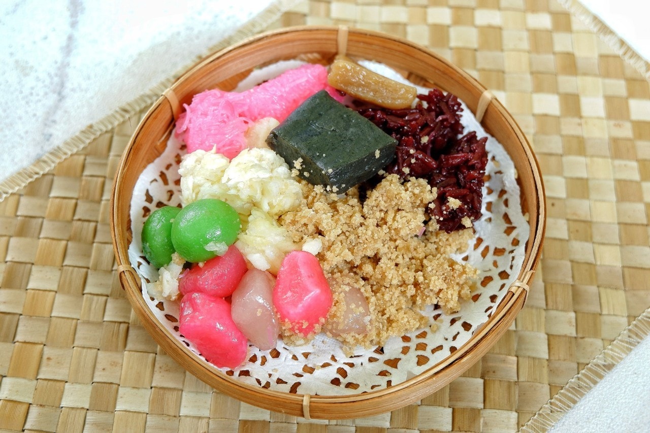 Piring saji rotan berisi cenil, tiwul, ketan hitam, dan getuk. 