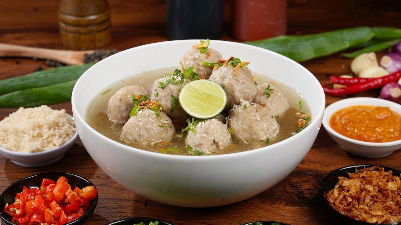 Semangkuk bakso beserta mangkuk kecil berisi pelengkap.