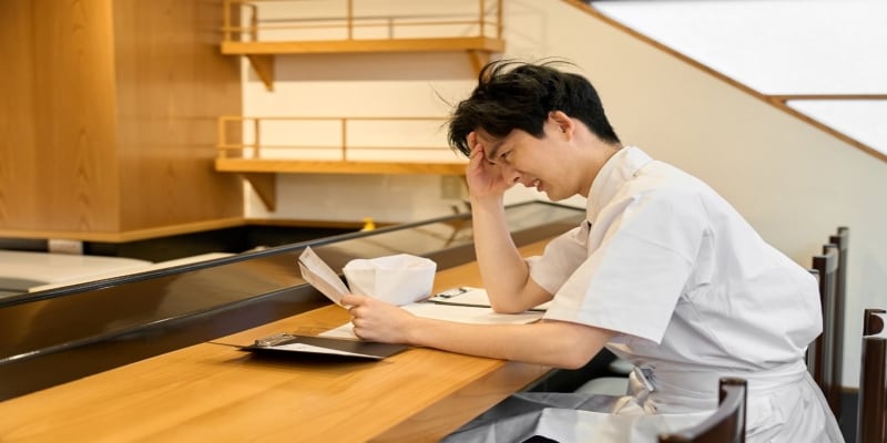 Chef muda sedang bekerja dengan paperwork-nya.