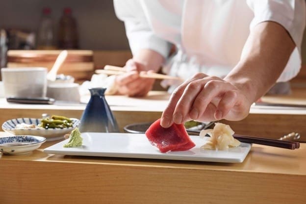 Tangan chef sedang plating tuna sushi untuk sajian omakase.  Tangan chef sedang plating tuna sushi untuk sajian omakase.