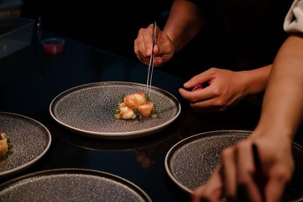 Tangan chef restoran di fine dining yang sedang plating.  Tangan chef restoran di fine dining yang sedang plating.