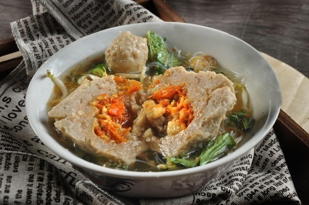 Seperti yang terlihat pada gambar, semangkuk bakso mercon dengan kuah dan sayuran