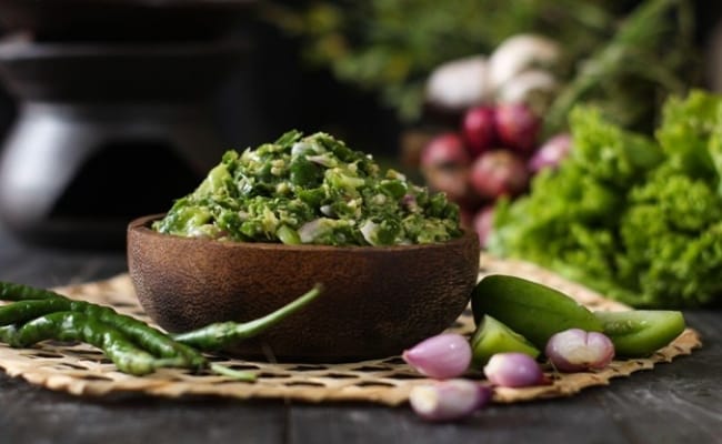 Sambal ijo dalam mangkuk kayu dengan bahan-bahan segarnya.