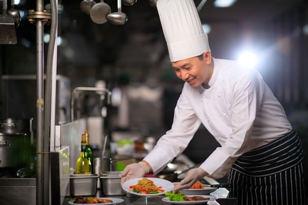 Seorang sous chef sedang menyiapkan hidangan pasta. Seorang sous chef sedang menyiapkan hidangan pasta.
