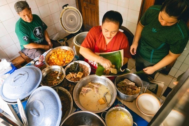 Penjual gudeg menyiapkan lauk dan sayur dalam deretan panci di sebuah warung di Semarang.