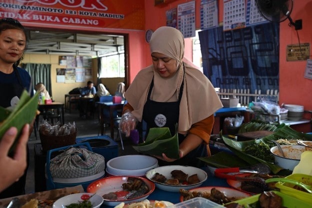 Penjual meracik pecel untuk pelanggan di warung pecel Madiun.