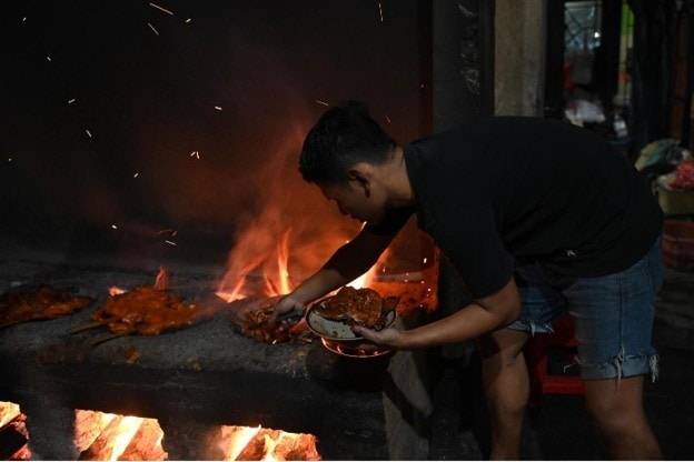 Ayam panggang dimasak di atas tungku kayu saat kunjungan kuliner di Magetan.