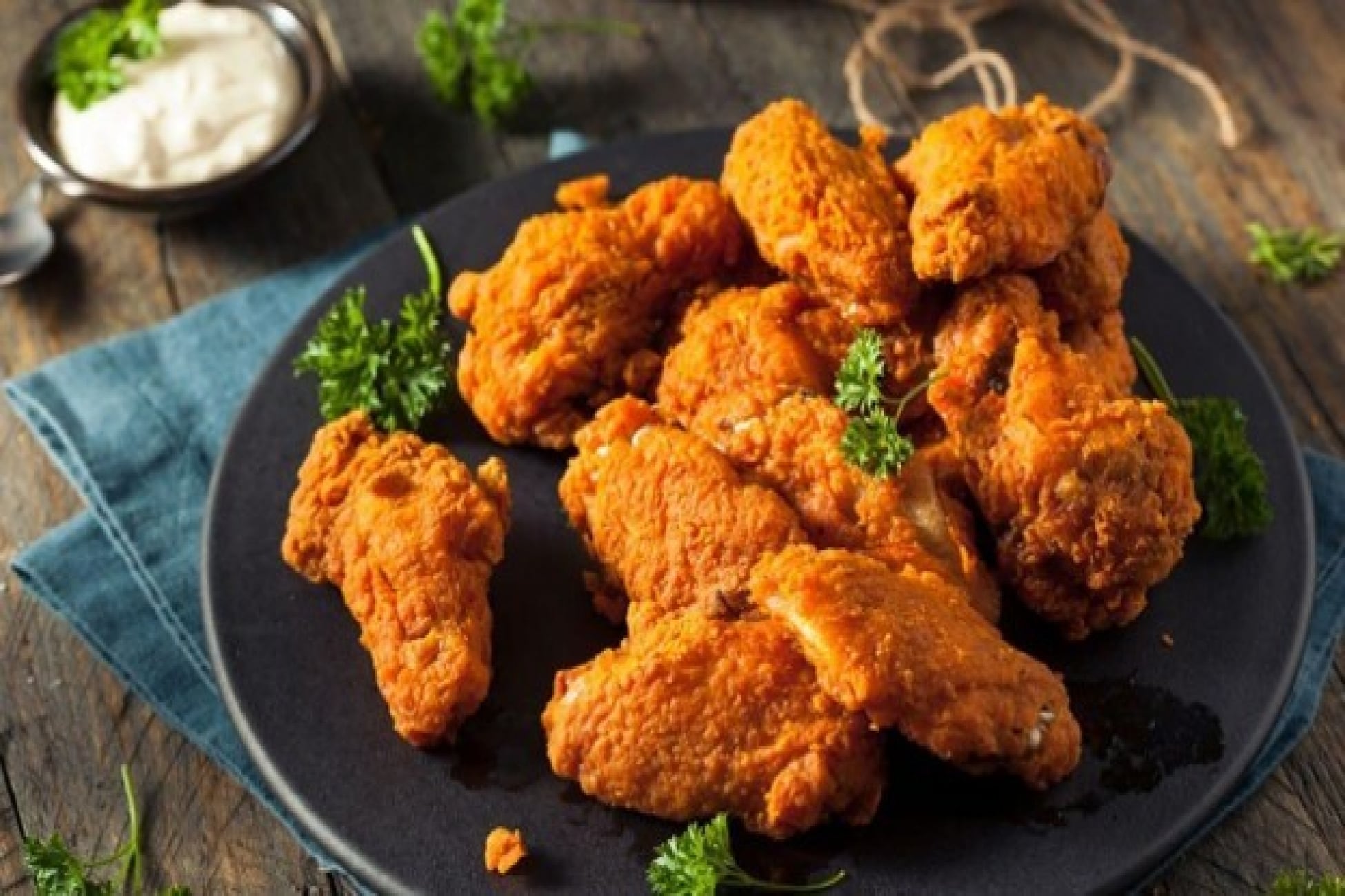Potongan ayam goreng krispi disajikan di atas piring dengan saus pendamping.