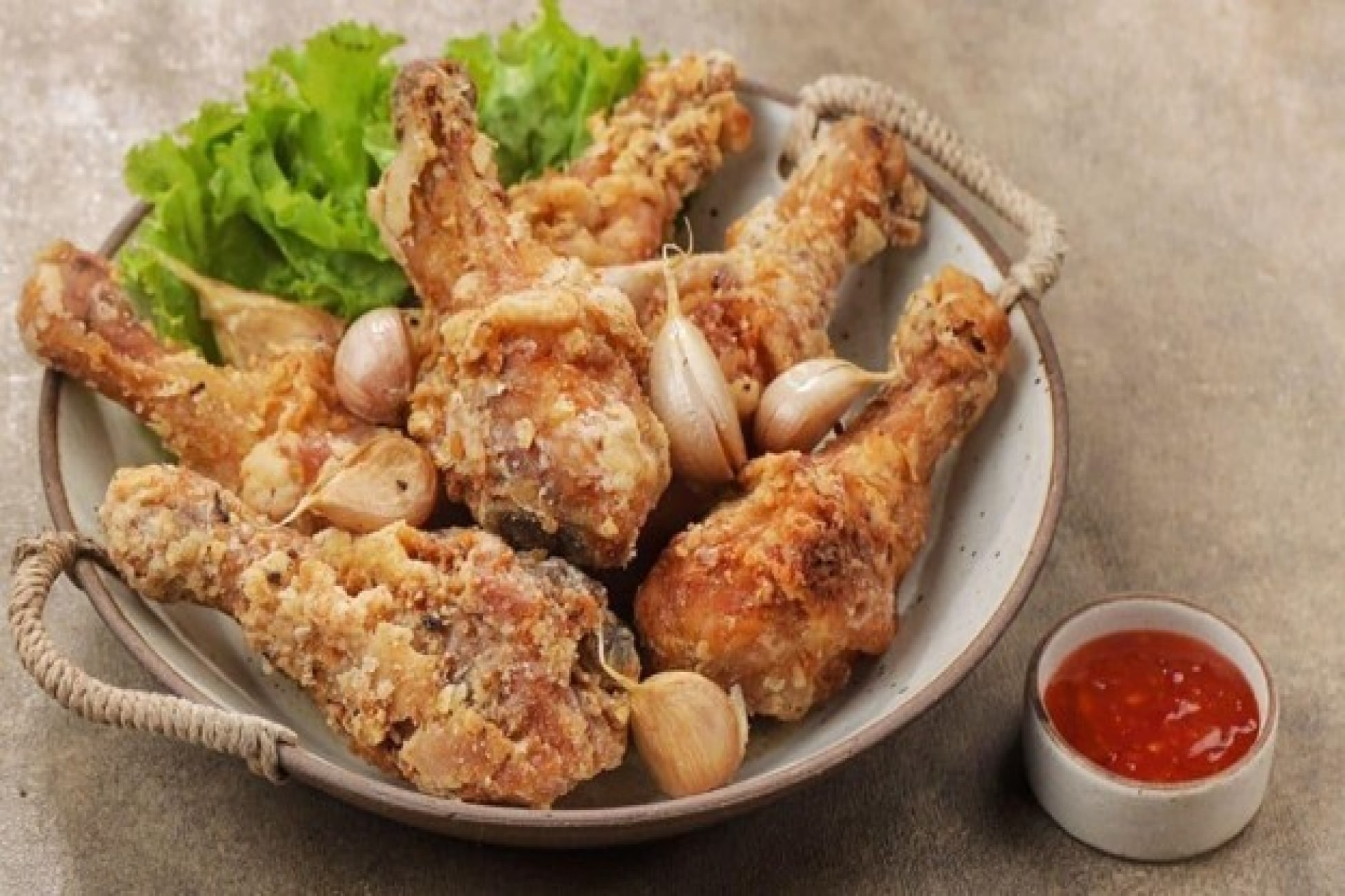 Ayam goreng bawang putih disajikan dengan cabai dan saus sambal.