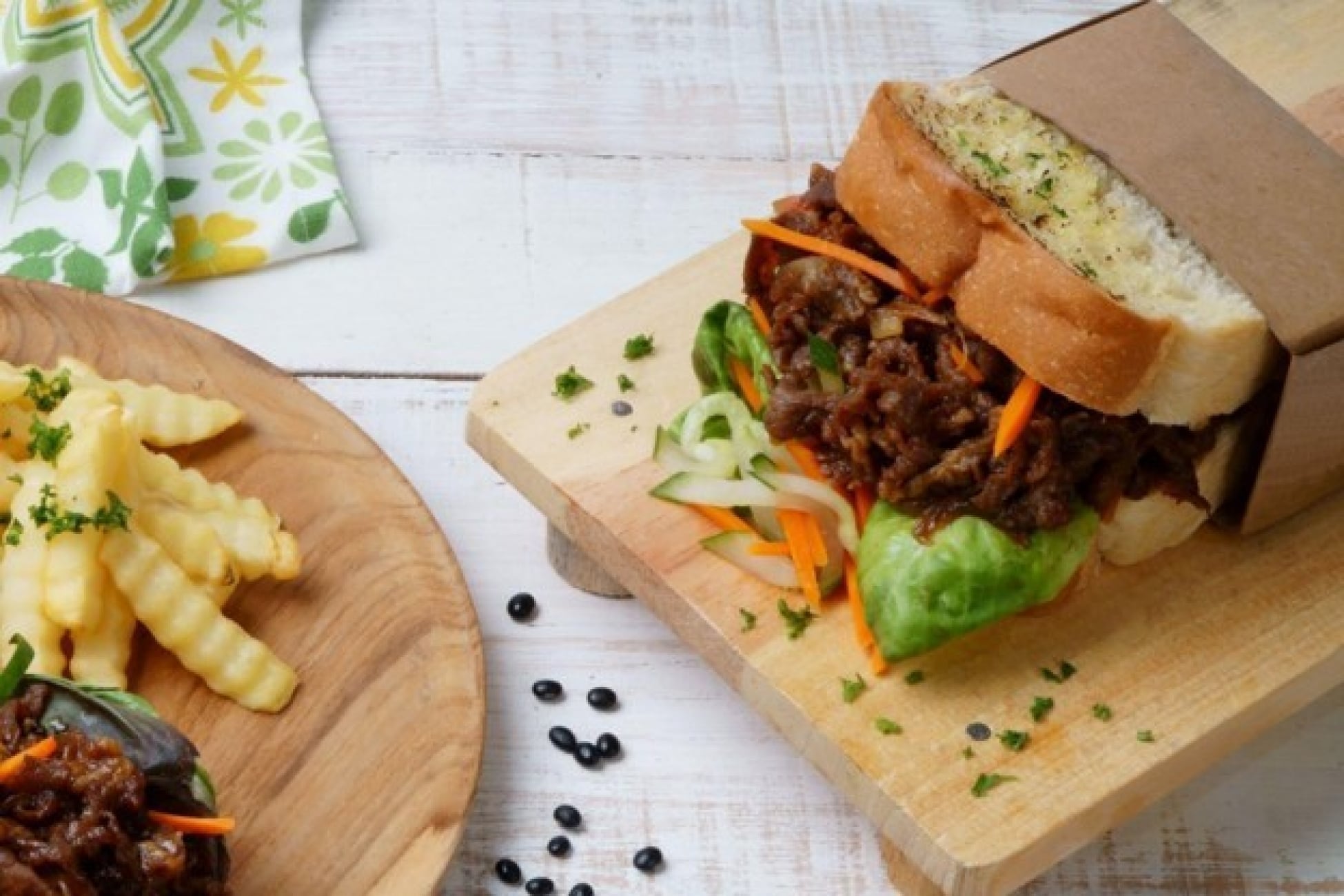 Sandwich berisi semur daging sukiyaki dan sayuran disajikan dalam kemasan kertas.