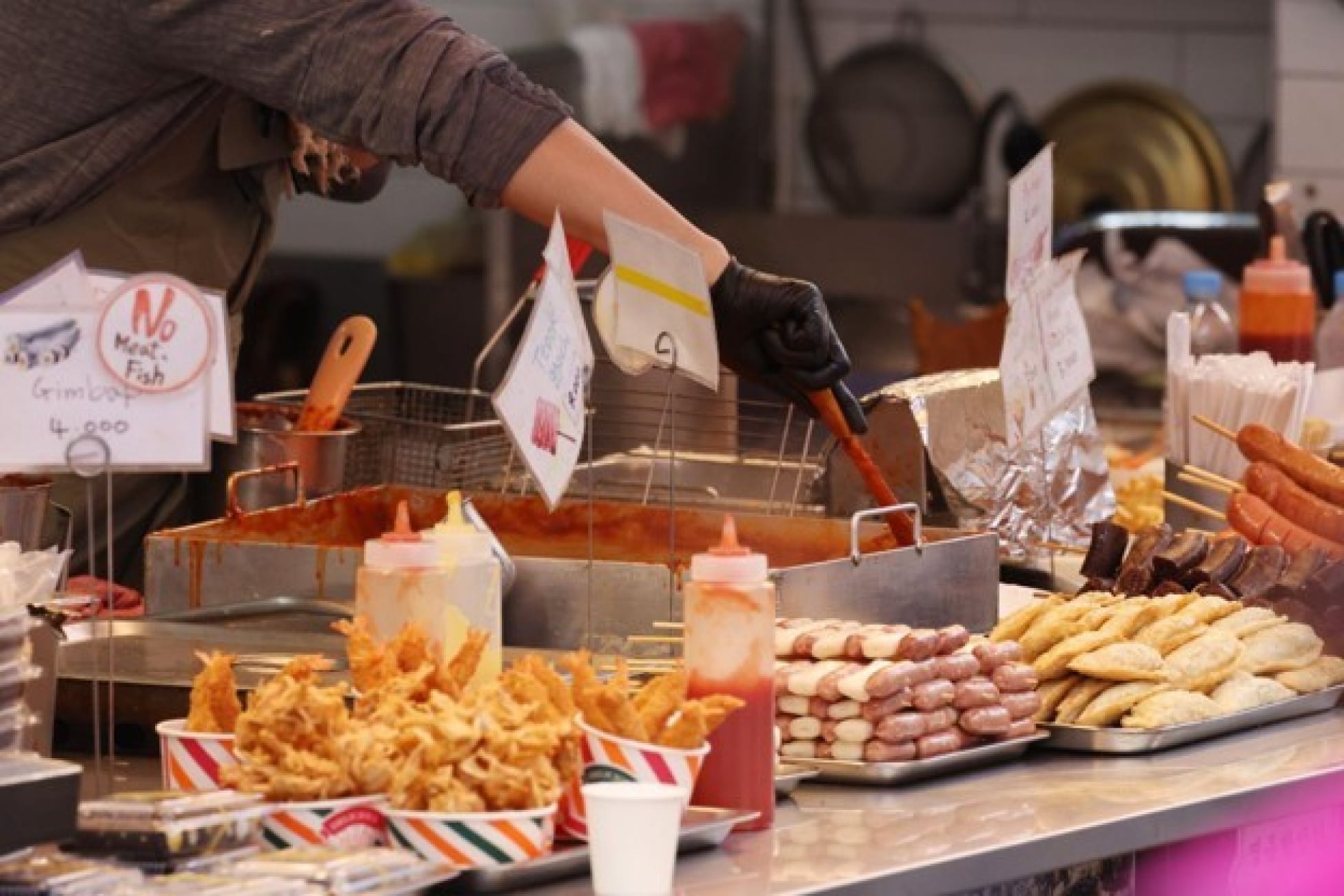 Penjual menyiapkan aneka jajanan Korea di booth bazar makanan.